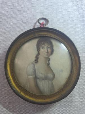 an old picture of a woman in a white dress is hanging on a wall