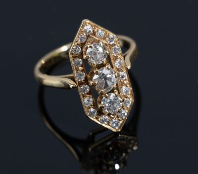 a close up of a gold and diamond ring on a black surface