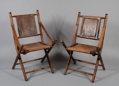 paire de chaises pliantes en bois avec assise et dossier en cuir marron