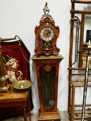 une horloge posée par terre à côté d'une chaise