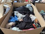 a cardboard box filled with clothes and other items