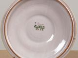 a white plate with a brown rim sitting on a table