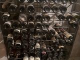 many bottles of wine sitting on a rack in a room