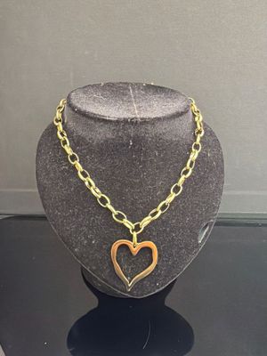 un collier en or avec un pendentif en forme de cœur sur un mannequin