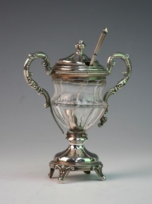 a silver vase with a spoon on top of it