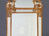 un miroir richement sculpté, avec un cadre doré sur fond gris