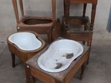 three old wooden chairs and a sink in a room