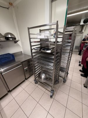 many trays of food on a metal rack in the kitchen