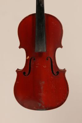 un vieux violon rouge auquel est accroché un archet noir sur le dos