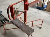 un petit chariot rouge avec un skateboard dessus, dans un garage