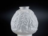 un vase en verre blanc orné d'un motif floral