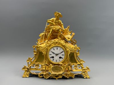 une horloge en or surmontée d'une statue