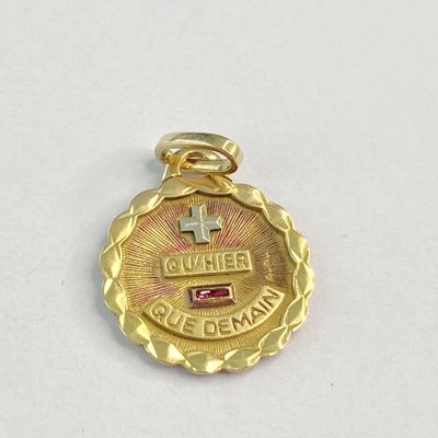 une image représentant une médaille d'or ornée d'une pierre rouge en son centre