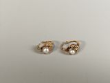 a pair of pearl earrings on a white surface