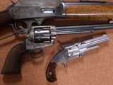 Deux revolvers sont posés l'un à côté de l'autre sur une surface marron