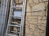 une échelle appuyée contre un mur de briques près d'une fenêtre