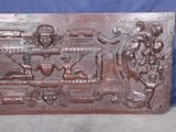 an antique carved wood panel with a man and woman on a bench