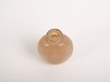 a small brown object on a white surface