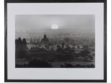 photographie en noir et blanc du soleil se couchant sur une ville