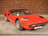a red sports car parked in front of a brick wall