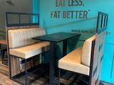 un stand avec deux chaises et une table, sur laquelle est posée une pancarte indiquant « Mangez moins, mangez mieux »