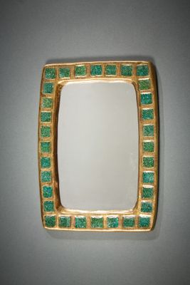 miroir carré doré et vert accroché au mur