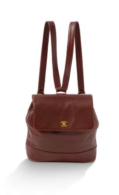 Le petit sac à dos est marron et comporte deux bretelles.
