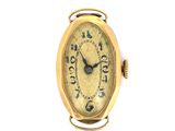 une petite montre en or dont le cadran est orné de chiffres romains