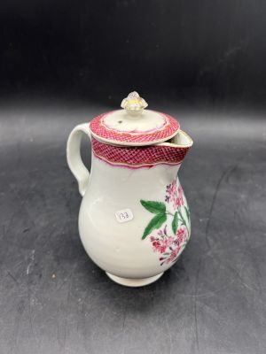 an image of a small pitcher with a lid on a table