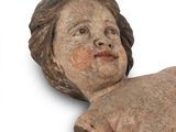 a small statue of a child laying on a rock