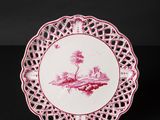 a pink and white plate with a bird on it