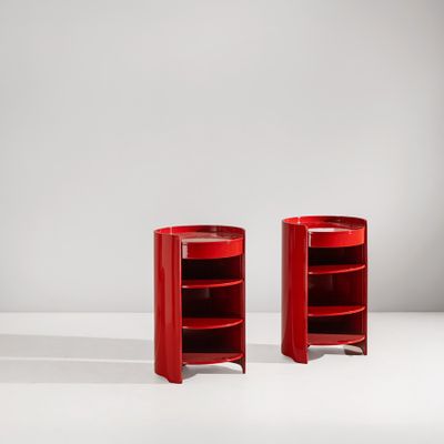 une paire de tables d'appoint rouges posées sur une surface blanche