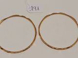 une paire de boucles d'oreilles en or sur fond blanc