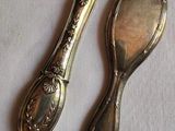 two silver spoons sitting next to each other on a table
