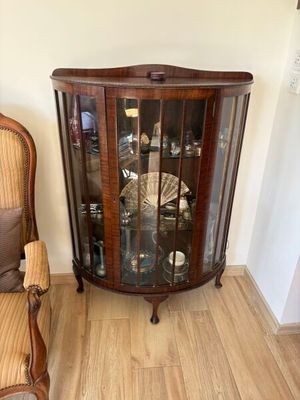 une chaise et une vitrine dans un coin de la pièce