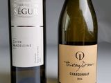 two bottles of wine sitting next to each other on a table