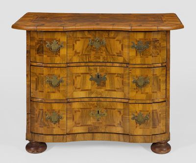 une commode ancienne avec un plateau en bois et des ferrures en laiton