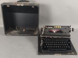 Deux vieilles machines à écrire sont posées l'une à côté de l'autre sur une table