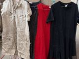de nombreux types de vêtements différents suspendus à un portant dans un entrepôt