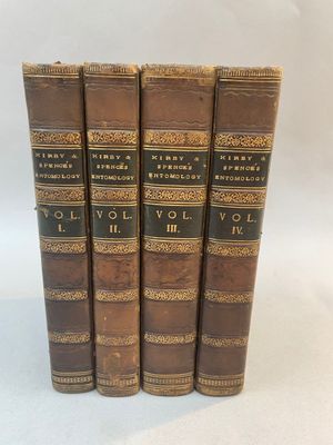 a set of four old books sitting on top of each other
