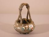 a small vase with a handle that has flowers on it