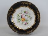 a black and gold plate with flowers on it