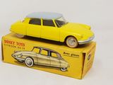 yellow toy car sitting on top of a yellow box on a white surface