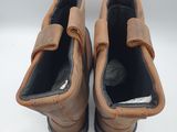 pair of brown leather shoes with buckles on them on a white surface