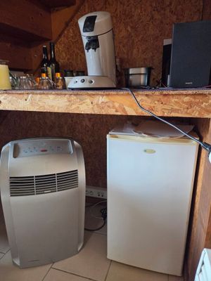 une photo d'une cuisine avec un réfrigérateur et un petit climatiseur