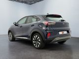 the rear end of a grey car in a large room