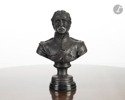 statue représentant le buste d'un homme, posée sur un socle posé à son tour sur une table