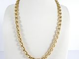 a close up of a gold chain necklace on a mannequin