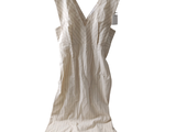 a white dress hanging on a hanger on a white wall