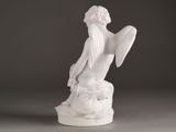 statue of a woman sitting on a rock with a bird in her hand